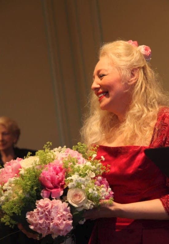 Melissa, soprano et professeur de chant, souriante avec un bouquet après un récital